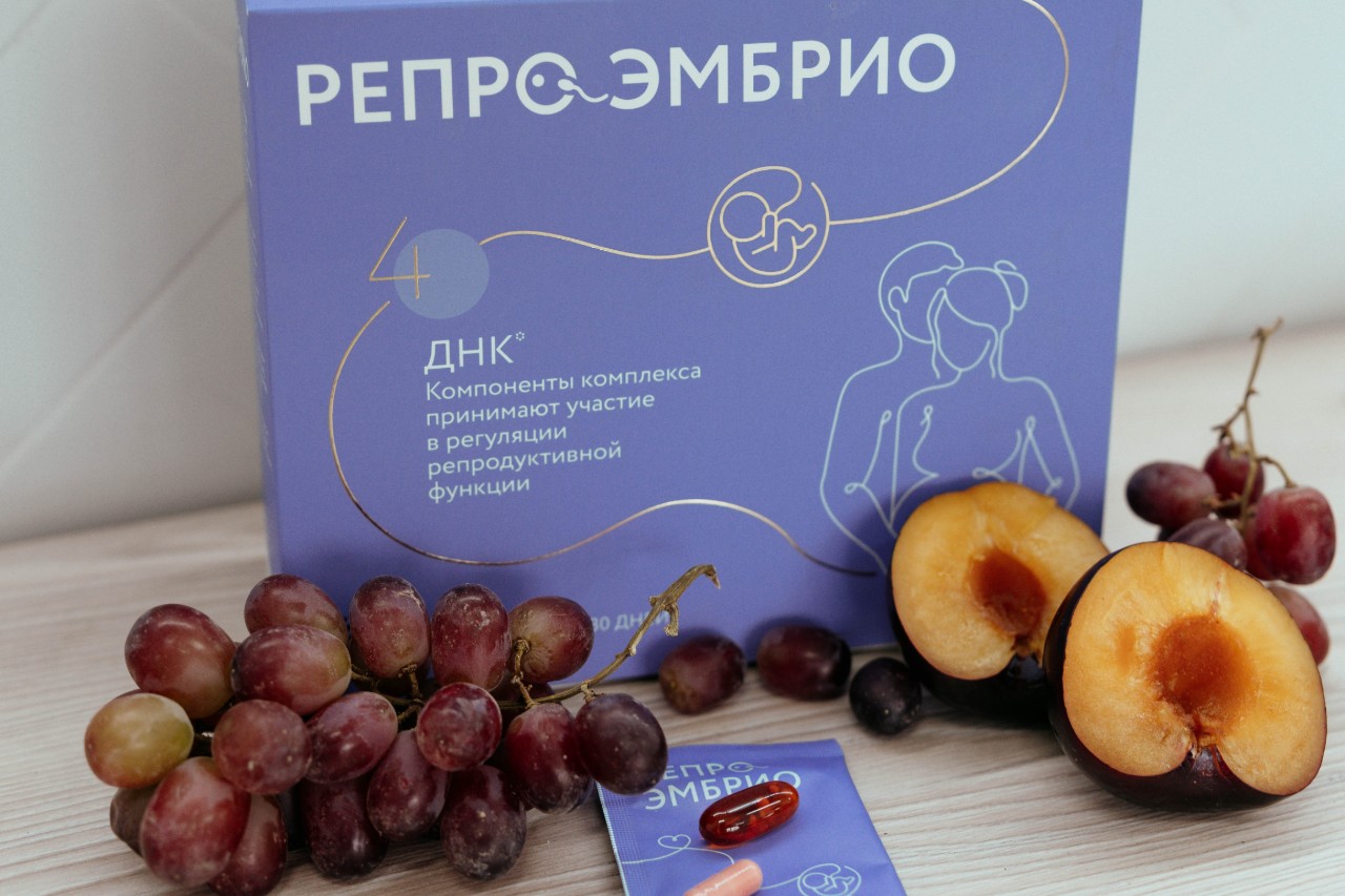 Комплекс витаминов РЕПРО для поддержки яйцеклеток, рядом свежие фрукты и капсулы.