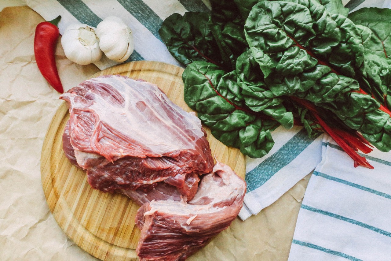 Свежие овощи и мясо на деревянной доске, ингредиенты для здорового питания и антиоксидантов.